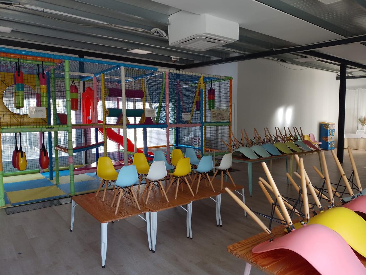 Parque de bolas con mesas infantiles preparadas para la fiesta